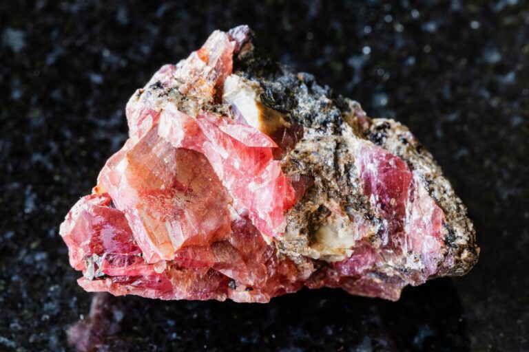 Sample,Of,Raw,Rhodonite,Mineral,On,Black,Granite,Background,Close