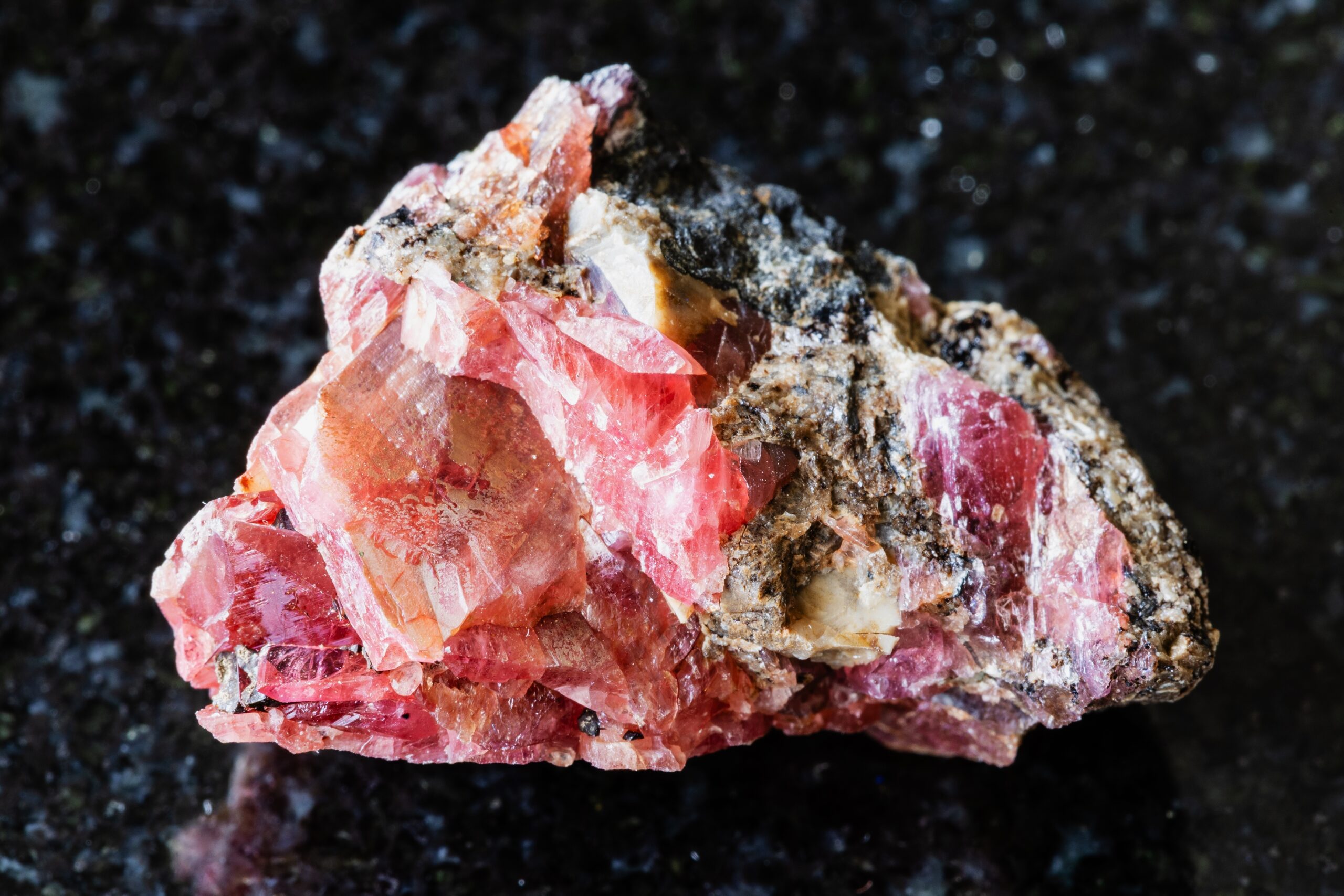 Sample,Of,Raw,Rhodonite,Mineral,On,Black,Granite,Background,Close
